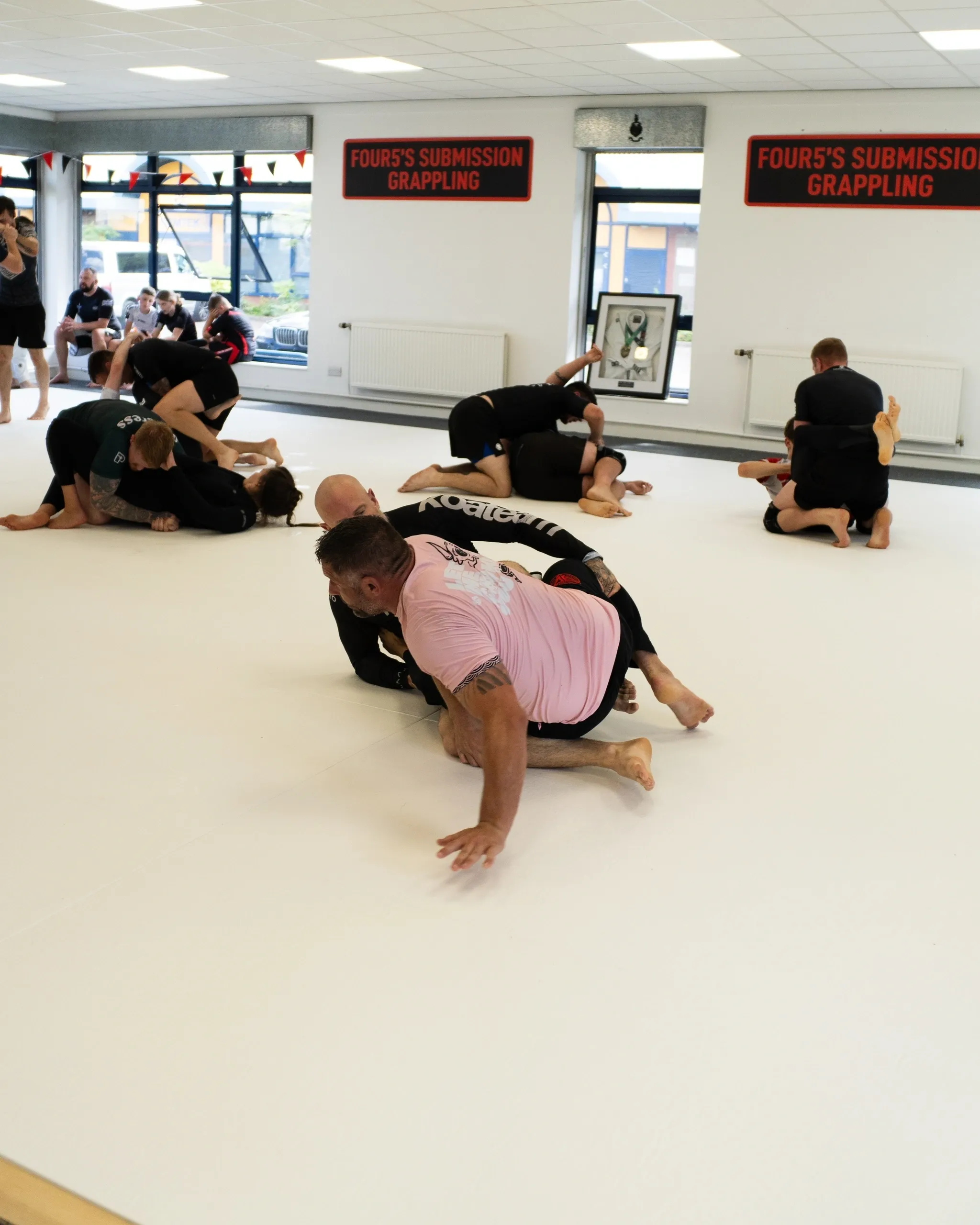 People practicing grappling in a gym.