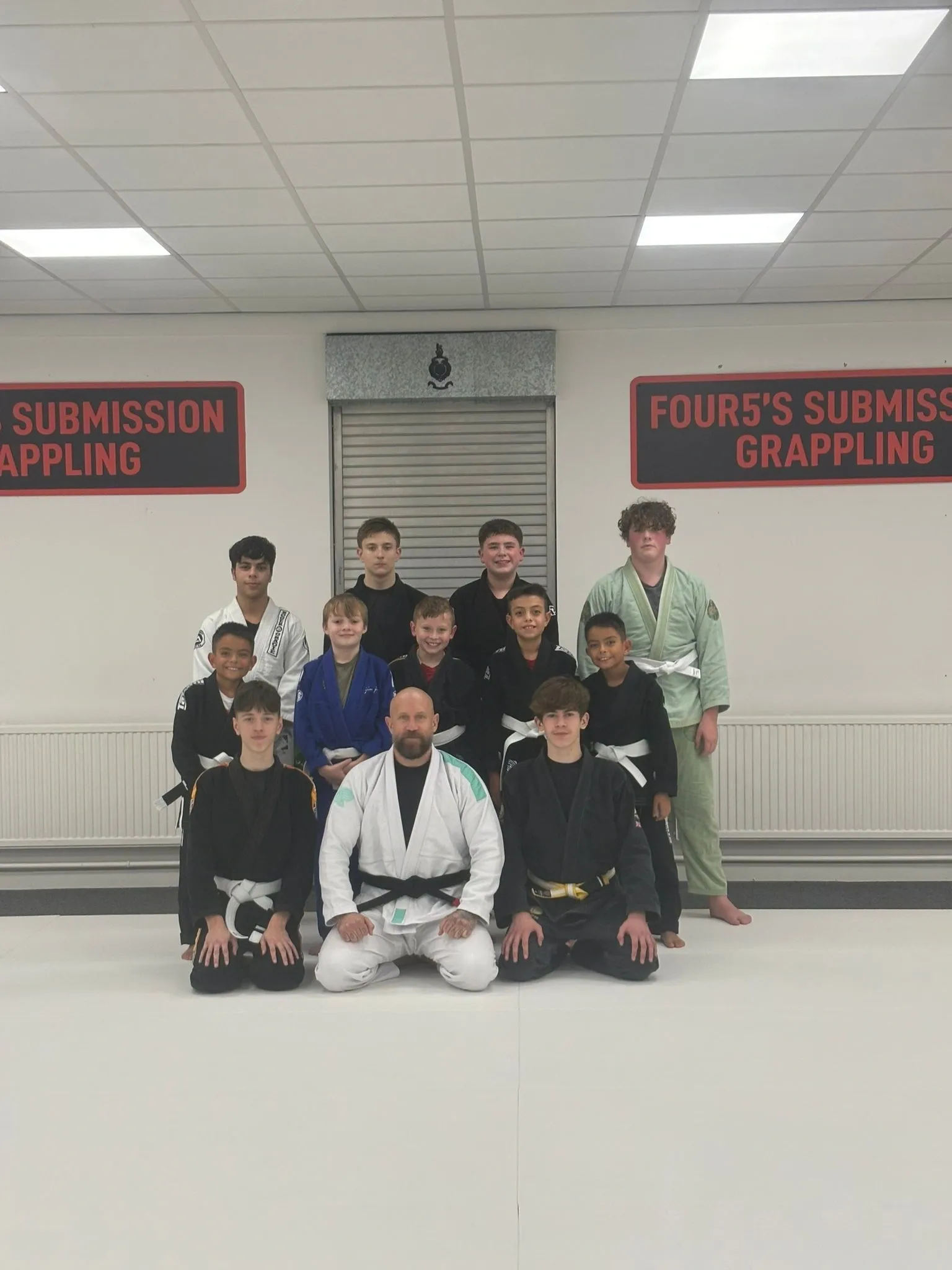 Martial arts group posing in training room.