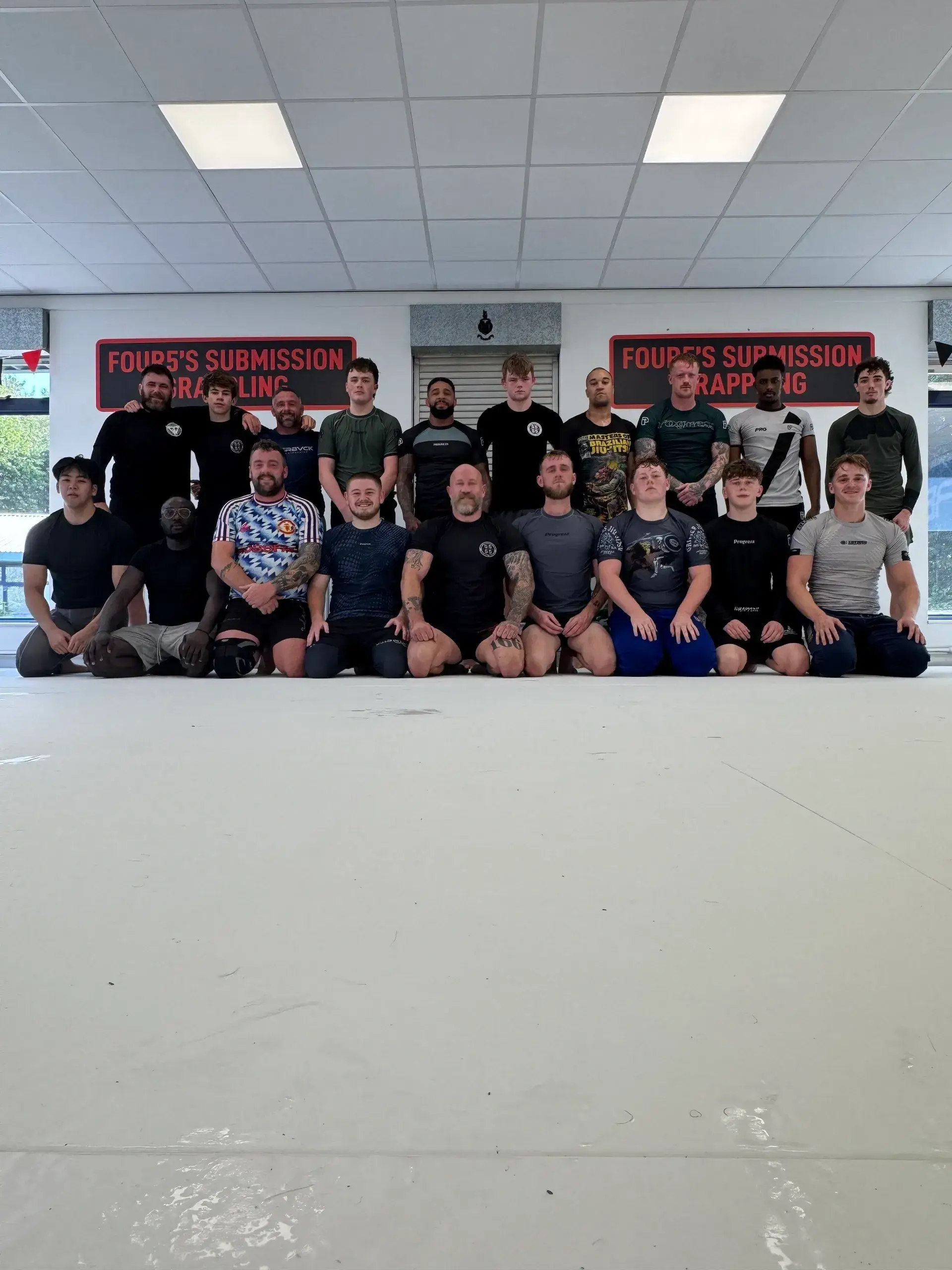 Martial arts group posing in training room.