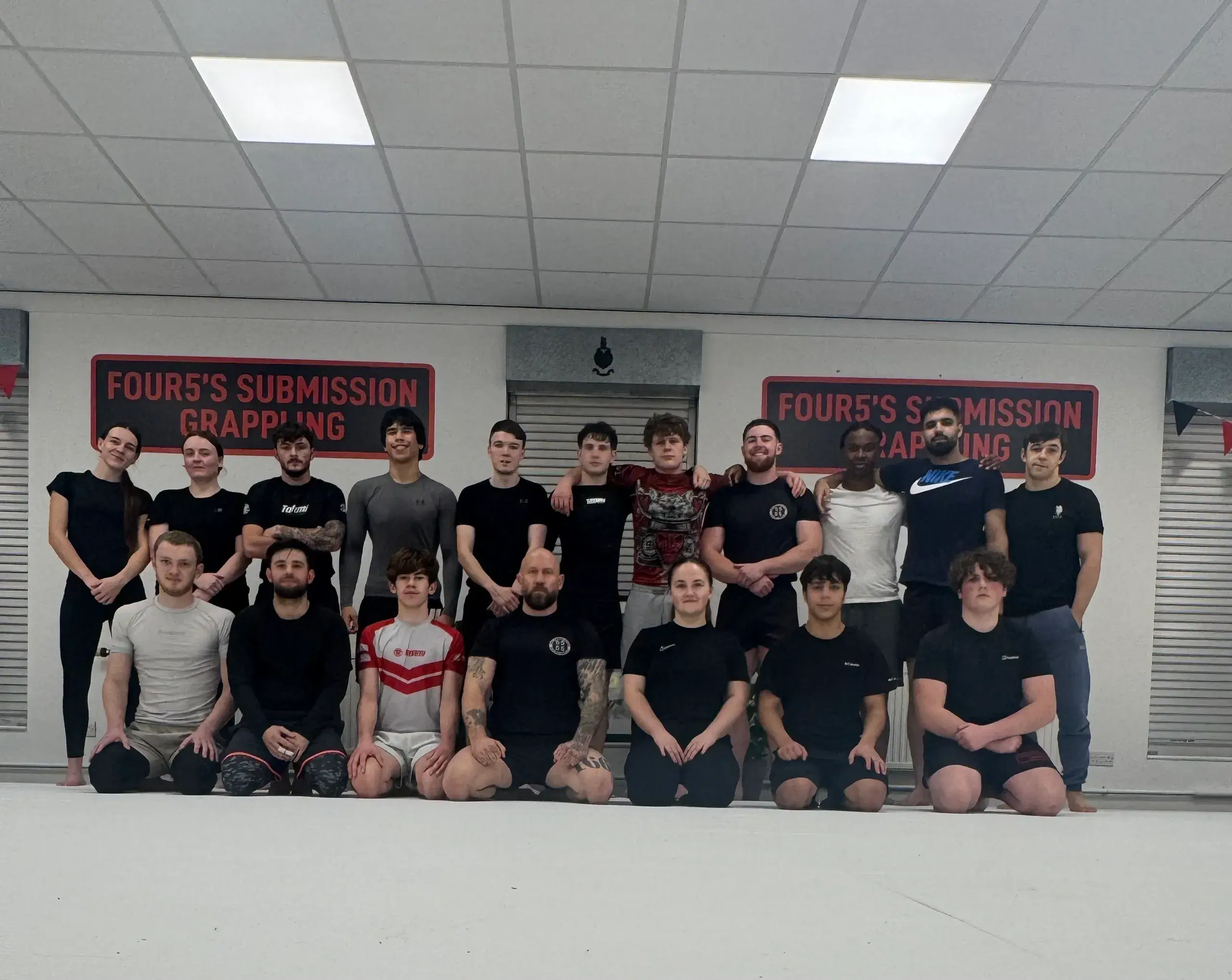 Group of people posing in gym setting.