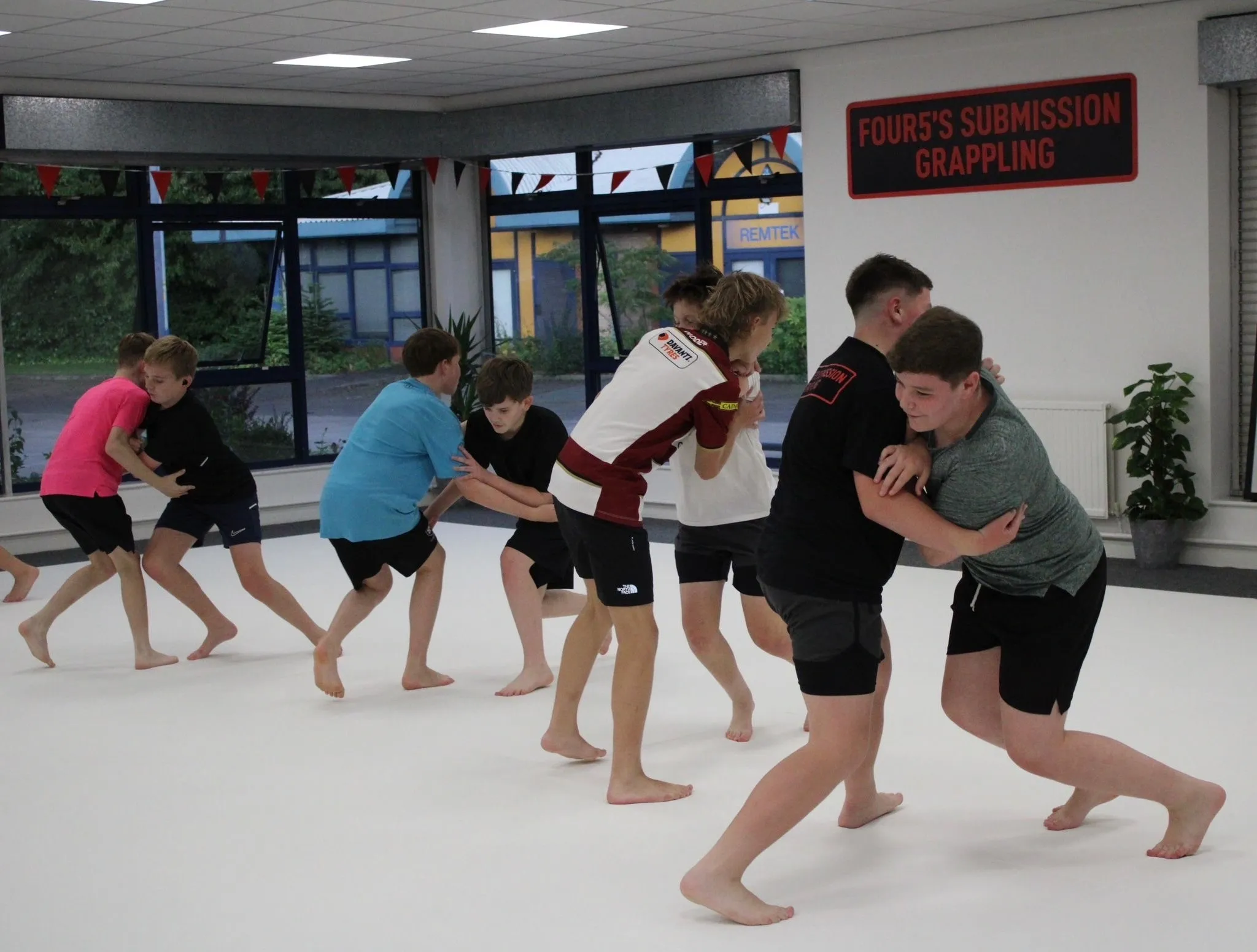 Children practicing grappling in a gym.